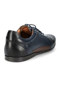 Granatowe skórzane buty z perforowanym wzorem i brązowymi akcentami, charakteryzujące się gładką fakturą i sznurowanym zapięciem, wykończone smukłą podeszwą.