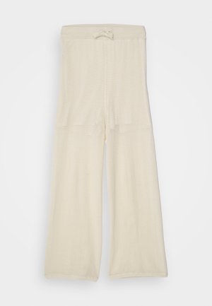 Svetlo béžové, široké nohavice z sieťoviny s pásom na šnúrku, ponúkajúce voľný strih a textúrovaný povrch. Vhodné na neformálne nosenie.
