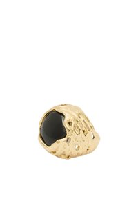 Anillo de oro con una superficie texturizada e irregular. Cuenta con una piedra negra redonda incrustada en el centro, con imperfecciones y detalles visibles.
