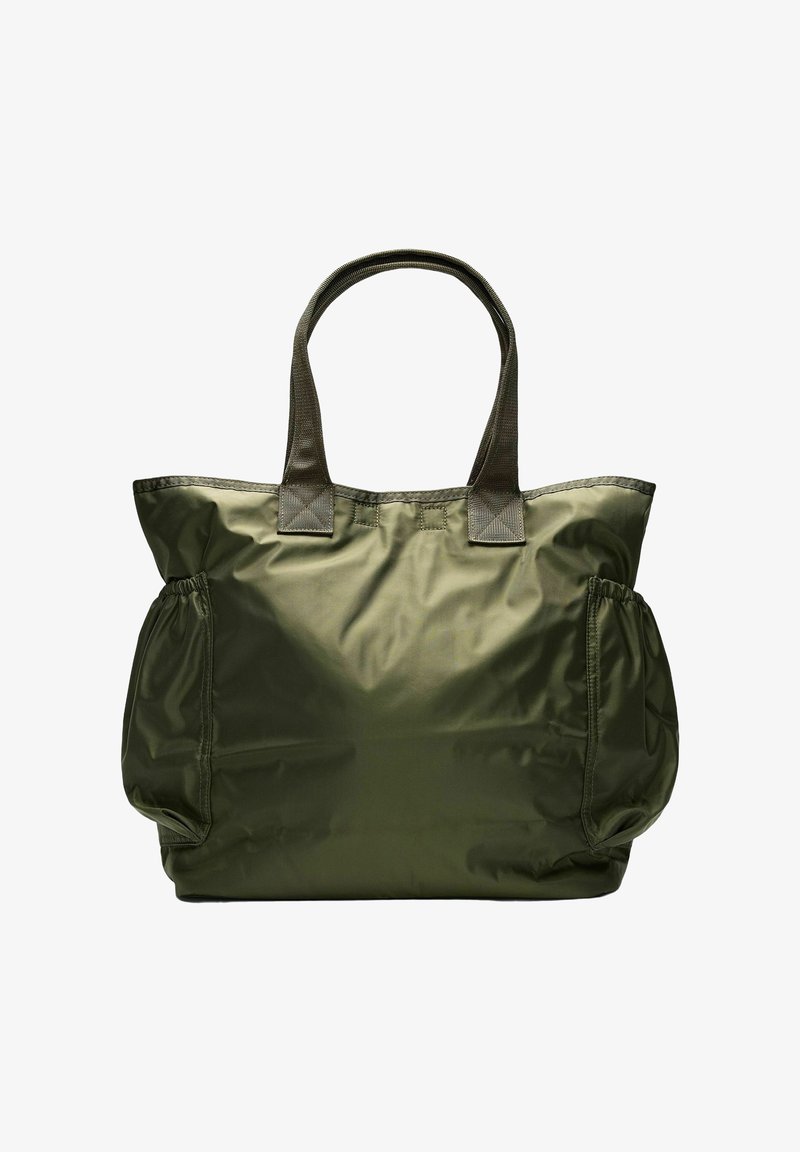 Sac fourre-tout en nylon vert olive avec doubles poignées et poches latérales élastiques, présenté sur un fond blanc.