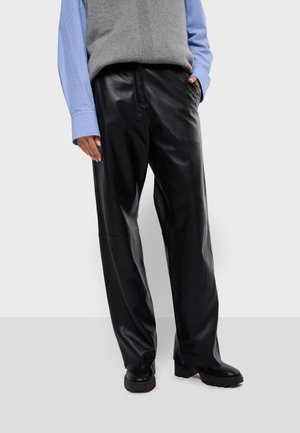 Pantalons en cuir noir avec une coupe décontractée, présentant une texture lisse, des jambes droites et un design classique. Associés à une chemise à col bleu clair.