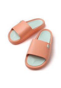 Sandalias de playa de color melocotón con una correa ancha, plantilla verde menta y un pequeño acento decorativo en la correa. Textura suave.