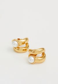 Gold hoop earrings with a smooth surface, featuring a round, white pearl accent. The design is curved and wraps around.