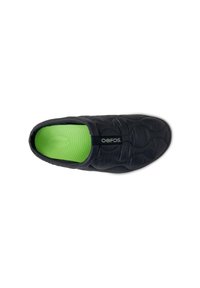 Schwarzer Slipper mit gestepptem Design, ausgestattet mit einer grünen strukturierten Einlegesohle und einem Logo an der Seite. Leichtes Material für Komfort.