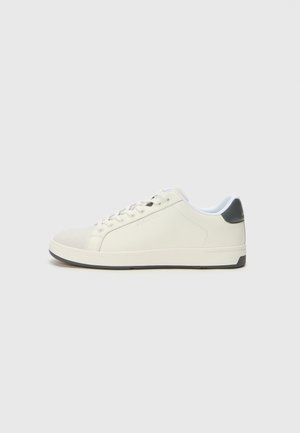 White sneaker with a smooth leather upper and grey heel accent. Features round laces, textured toe cap, and a rubber sole.