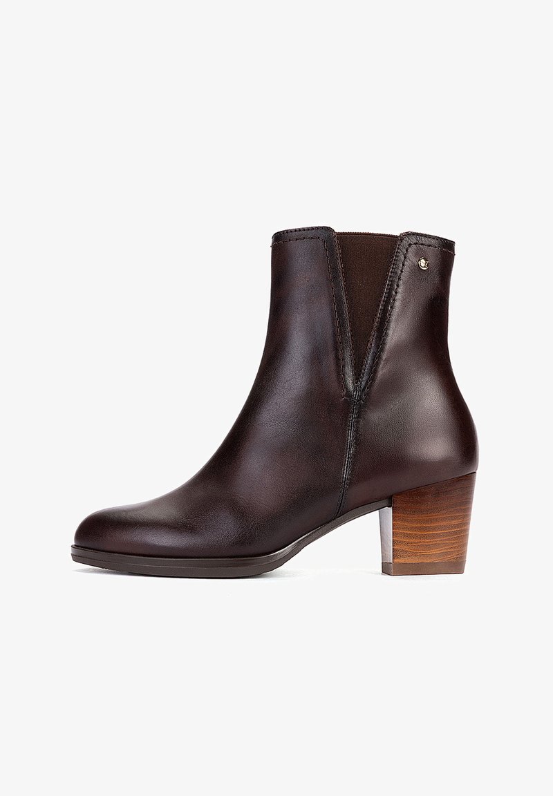 Bottine en cuir marron foncé avec un petit talon bloc en bois et des panneaux élastiques sur les côtés pour un enfilage facile.