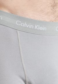 Boxer briefs grigi in cotone con una morbida cintura con il logo "Calvin Klein". Il tessuto è liscio, con un design aderente e cuciture piatte.