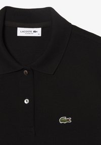 Svart Lacoste polo av klassisk passform, med en texturerad tyg, tre knappar fram och en broderad grön krokodil-logotyp.