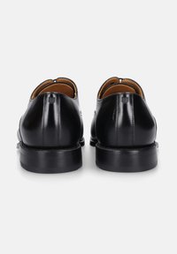Schwarze Lederschuhe mit einem eleganten Design, runder Zehenpartie, weichem Innenfutter und einer robusten schwarzen Sohle mit sichtbaren Nähdetails.