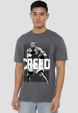 Gray cotton t-shirt featuring a front graphic of a boxer, with bold white text reading "CREED" underneath the image.