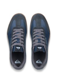 Tennarit merensinisen ja harmaan värisinä, joissa on mokkanahka- ja nahkapinta, harmaat nauhat, kumipohja ja logotieto kielekkeessä.