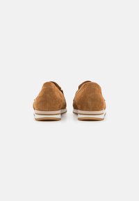Bruine suède schoenen met een ronde neus, zij-elastieken voor een goede pasvorm en een wit gestreepte zool. Gestructureerd bovenwerk en een gevoerde hak.