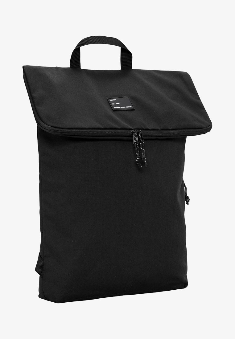 Zwarte rugzak met een vouwflap, ritsluiting, handvat aan de bovenkant en zijzak. Gemaakt van duurzaam materiaal, met een strak, minimalistisch ontwerp.