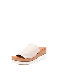 Sandalo platform in pelle crema con una cintura larga, sottopiede in legno e suola in gomma bianca, caratterizzato da una superficie liscia e un design minimalista.