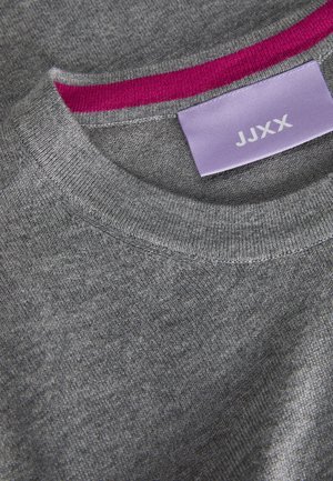 Gray knit sweater with a ribbed crew neckline. Pink inner neck accent. Label visible with "JJXX" on a light purple background.