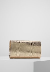 Metaliczna złota kopertówka z teksturowanym wzorem węża. Prostokątny kształt, gładka powierzchnia i brak widocznych detali sprzętowych.