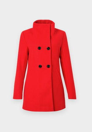 Czerwony wełniany płaszcz z wysokim kołnierzem, dwurzędowym zapięciem na czarne guziki, dwoma bocznymi kieszeniami i dopasowanym krojem.