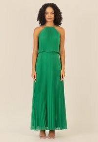 Grünes, plissiertes Maxikleid mit Halspartie und Perlenakzenten. Leichter Stoff mit fließender Silhouette und transparenter Saumgestaltung.