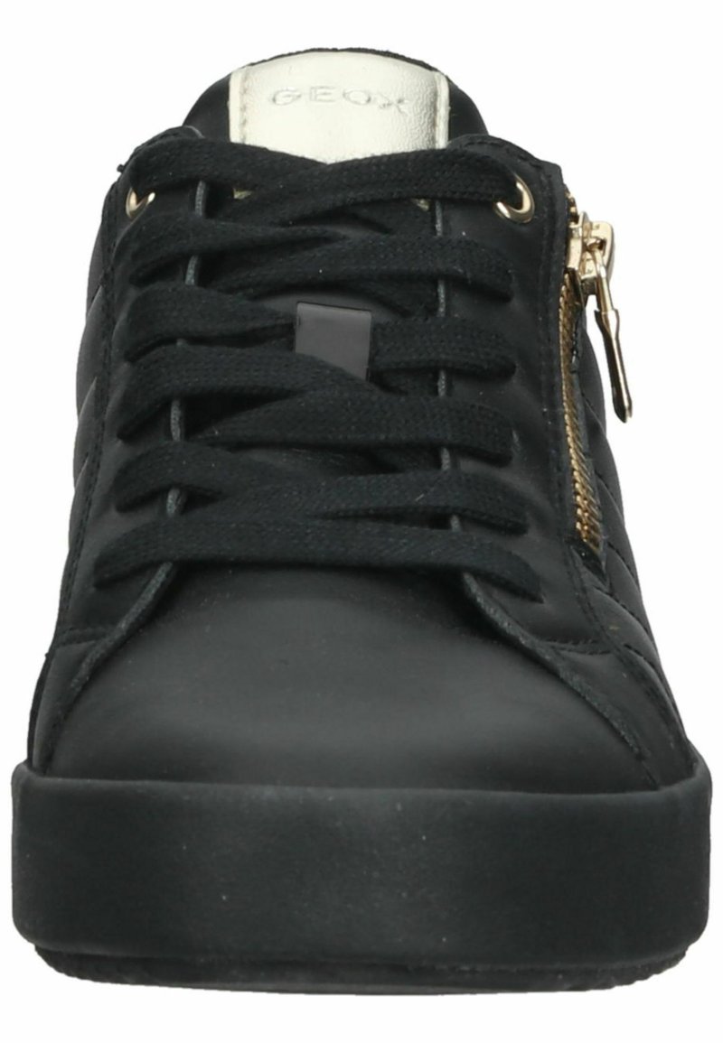 Sneaker nera con superiore in pelle liscia, lacci testurizzati e un accento di zip dorata sul lato. Suola piatta in gomma per aderenza.