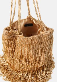 Borsa a mano con perline dorate, design frangiato, interno in satin e doppie catene. Presenta un elaborato ricamo di perline e una texture morbida.