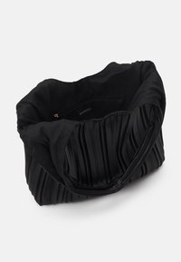 Sort totebag med plisseret tekstur og glat øverste kant. Den har et stofmateriale, en rummelig indre og en lynlås lomme indeni.