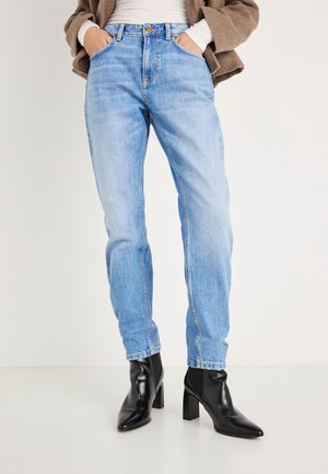 Lichtblauwe denim jeans met een rechte pasvorm en een hoge taille. Draagt zwarte enkellaarsjes met hak. Soepele textuur, klassiek ontwerp met vijf zakken.