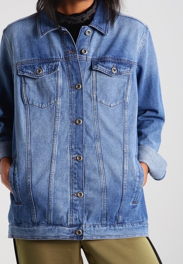 Světle modrá džínová bunda s knoflíkovým zapínáním, dvěma náprsními kapsami a bočními kapsami. Ošoupaný vzhled s viditelnými švy a prošitím.