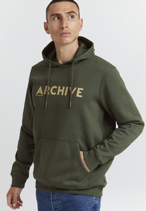 Olive green hoodie with "ARCHIVE" printed in gold. Soft cotton blend, kangaroo pocket, drawstring hood, ribbed cuffs, and hem.