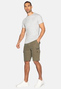 Grijze t-shirt met korte mouwen, olijfgroene cargoshorts met zakken, witte sneakers. Casual outfit met eenRelaxed fit en duurzame stof.