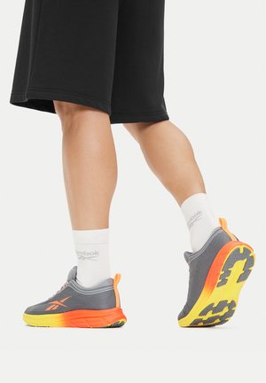 Szare buty sportowe z pomarańczowo-żółtymi gradientowymi akcentami, lekką konstrukcją, fakturowanym materiałem oraz gumową podeszwą z bieżnikiem zapewniającym przyczepność.