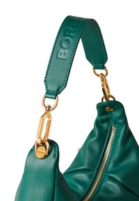 Borse in pelle color turchese con clip e zip in tono oro. La tracolla è impreziosita dalla scritta "BORB", evidenziando una texture liscia e un design curvo.