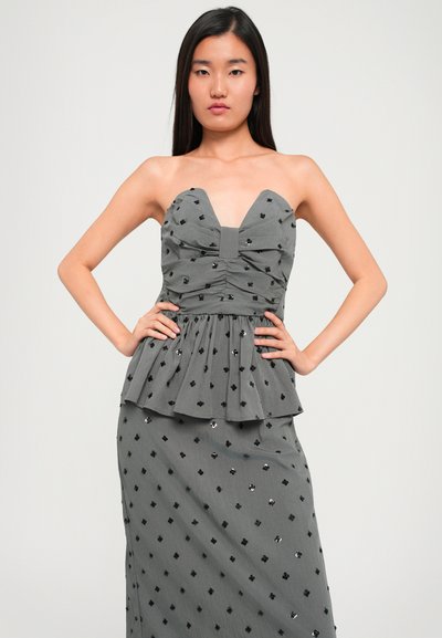 Α strapless γκρι φόρεμα με sweetheart neckline, ραμμένο κορσέ, peplum μέση και σκορπισμένα μαύρα στρας στη φούστα. Λείο υλικό.