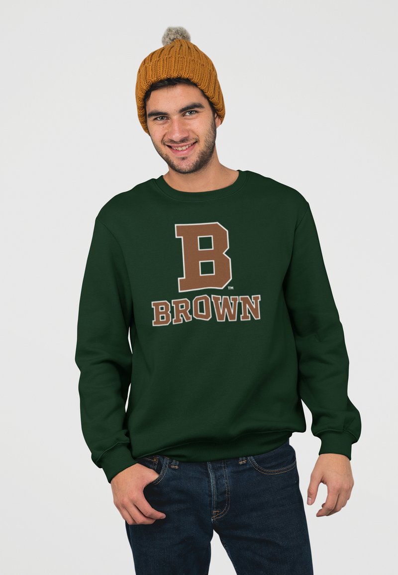 Felpa verde scuro con una grande "B" marrone e la scritta "BROWN". Indossata con un berretto lavorato a maglia giallo senape con un pompon in cima.