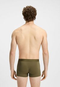 Boxer briefs verde oliva con una morbida cintura elastica, progettati per una vestibilità aderente. Texture liscia, stile minimalista, vista posteriore.