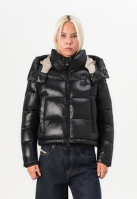 Schwarze Daunenjacke mit glänzender Oberfläche, hohem Kragen und hellgrauem Innenfutter. Verfügt über große gesteppten Abschnitte und einen Frontreißverschluss.