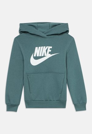 Tirkizna otroška kapa s kapuco z žepom spredaj in belim logotipom Nike ter kljukico na prsih, izdelana iz mehke tkanine z rebrastimi manšetami in robom.
