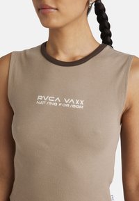 Brązowy prążkowany top na ramiączkach z okrągłym dekoltem, z białym haftem tekstu "RVCA VAXX" oraz "NAT/ING FOR/DOM".