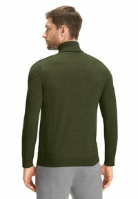 Dunkelgrüner Rollkragenpullover aus einem weichen, strukturierten Strickstoff, mit langen Ärmeln und einer figurbetonten Silhouette. Keine sichtbaren Muster.