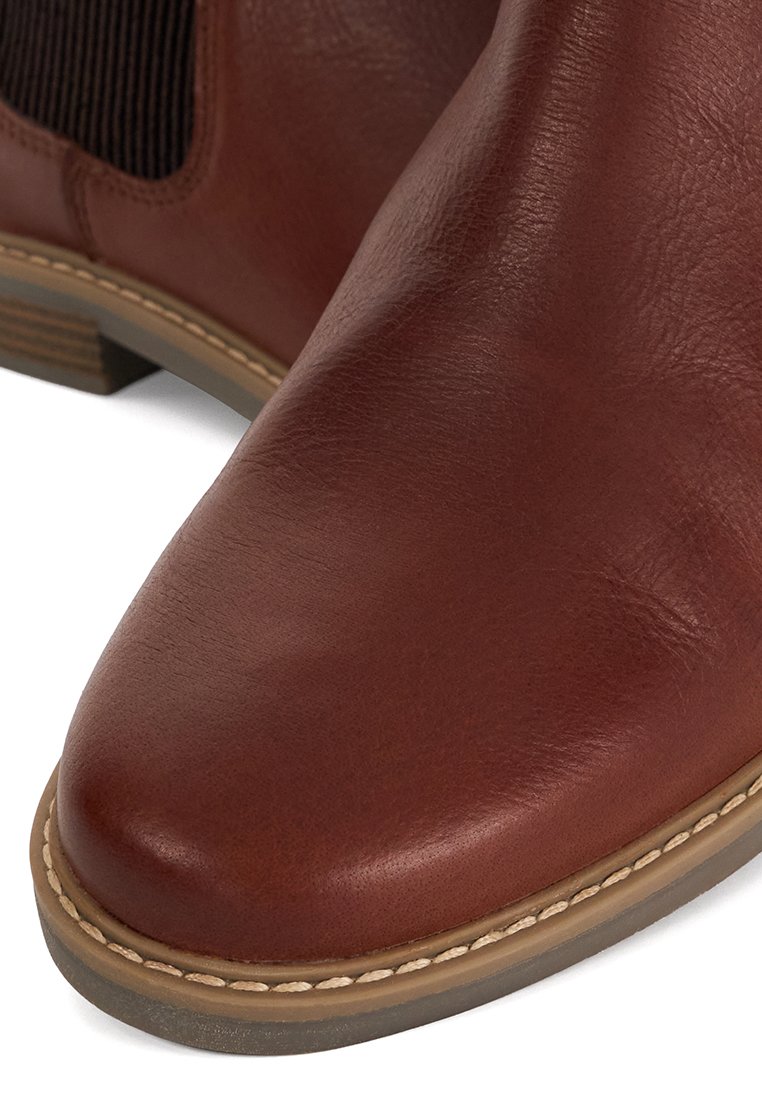 Braune Leder-Ankle-Boots mit abgerundeter Spitze, strukturierten elastischen Seitenpaneelen und einer genähten beigen Sohle. Klassisches Design mit dezentem Glanz.