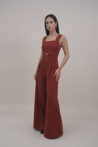 Roodbruine jumpsuit met wijde benen, getailleerd lijfje, vierkante halslijn en een riem met een rechthoekige gesp. Soepele stofstructuur.