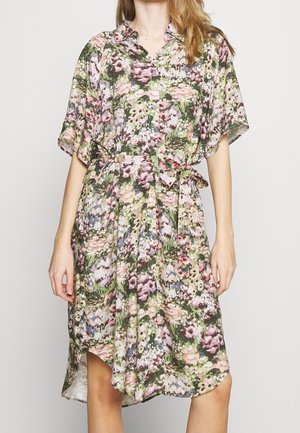 Vestido con estampado floral que presenta un cuello, mangas cortas, cintura con cinturón y un dobladillo más largo en la parte trasera. Confeccionado con tela ligera.