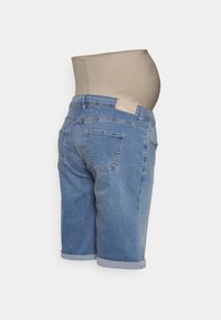 Calções de maternidade em denim com um tom azul claro, corte de altura média, bainhas dobradas e uma cintura elástica bege para suporte.