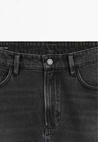 Jeans in denim nero con un design classico, caratterizzati da una chiusura frontale con bottone, cinque tasche e una trama visibile nel tessuto.