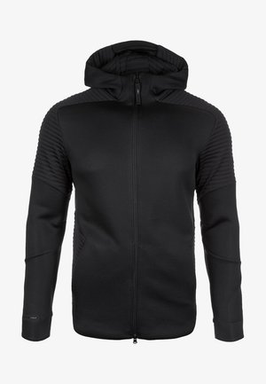 Sudadera negra con cremallera completa, hombros y parte superior de las mangas con textura de canalé, puños ajustados y cuello alto que se extiende hasta la capucha.