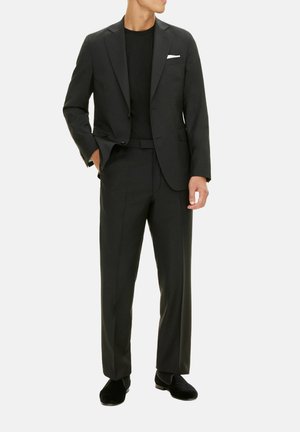 Schwarzer maßgeschneiderter Anzug mit einem einreihigen Blazer, passender Hose und einem einfarbigen schwarzen Hemd. Inklusive weißem Taschentuch. Glatte Textur.