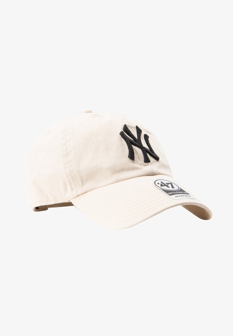 Cappellino in cotone beige con ricamo nero "NY" logo, visiera curva, cinturino regolabile sul retro e un'etichetta con i dettagli del marchio.
