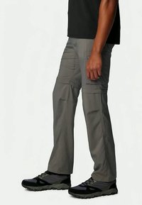 Hallid hallid cargo püksid, millel on mugav lõige, mitmete küljetaskutega, tugevdatud õmblused ja kerge, vastupidav materjal. Kombineeritud mustade jalatsitega.