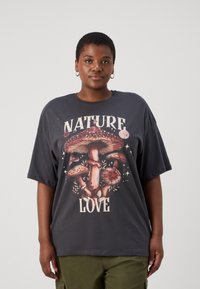 T-shirt graphique en coton gris foncé avec un design de champignon coloré et le texte "AMOUR DE LA NATURE" ; coupe décontractée et manches courtes.