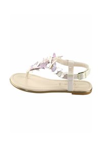 Sandales plates avec une semelle beige, ornées d'un design floral en violet clair, de brides translucides et d'une fermeture à boucles au niveau de la cheville.
