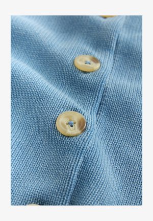 Light blue knitted fabric featuring two button fastenings made from beige material, with a subtle texture.